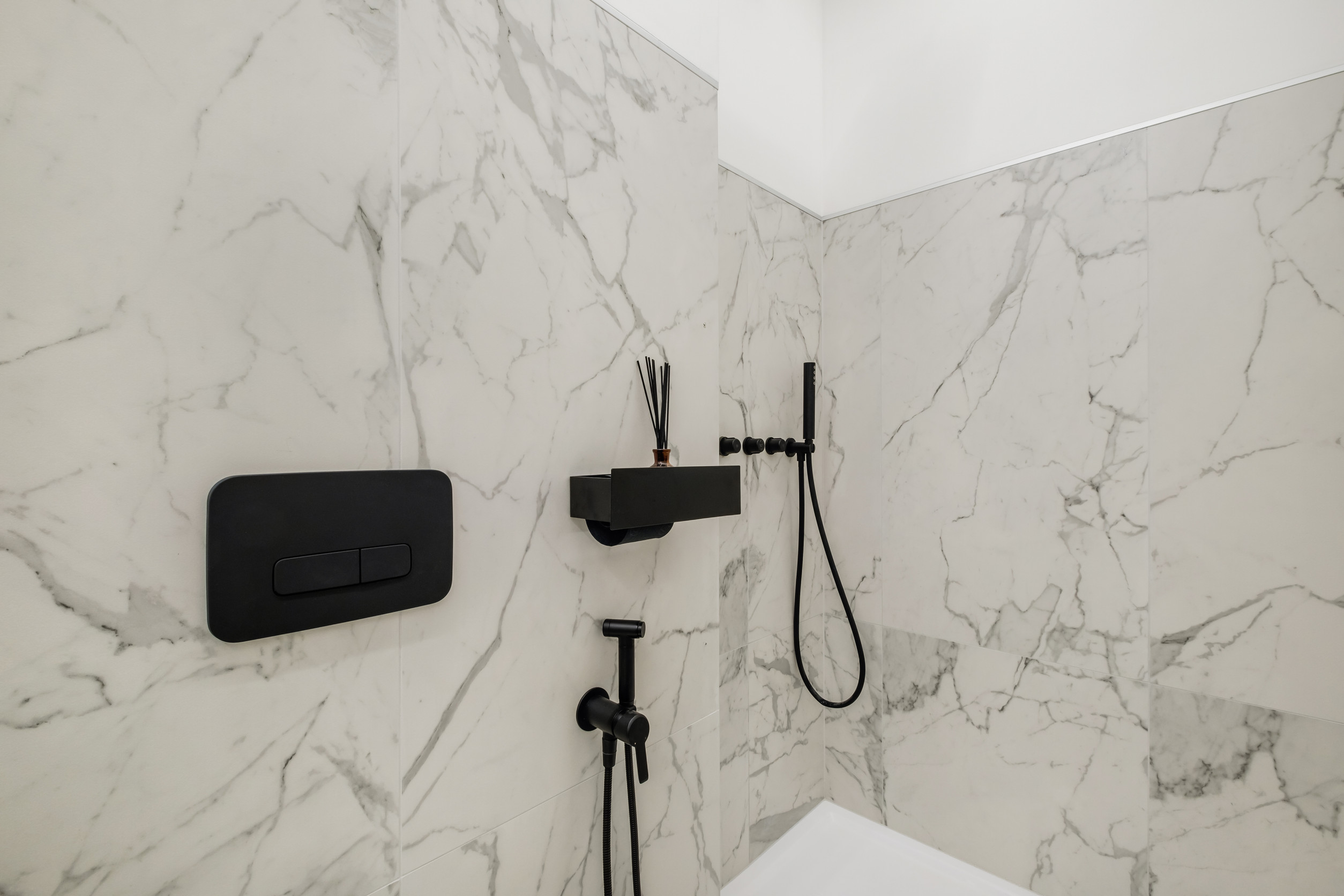 toilet and detail of a corner shower cabin with wall mount shower attachment toilet and detail of a corner shower cabin with wall mount shower attachment