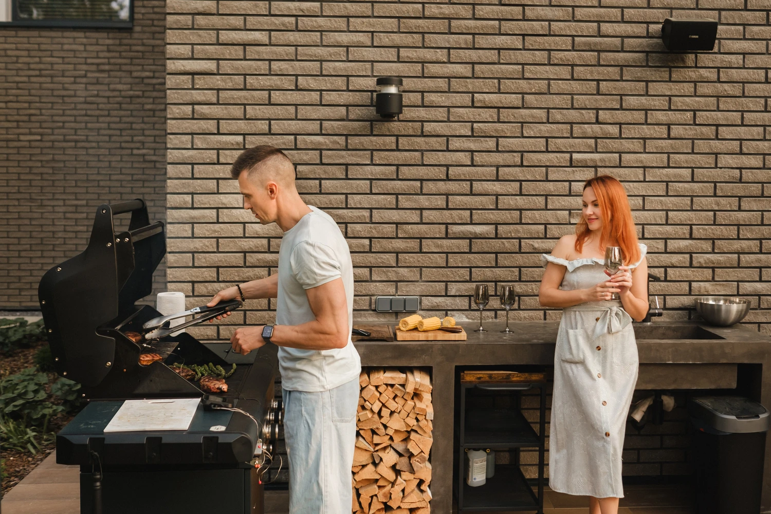 207167541_m (1) A married couple cooks grilled meat together on their terrace.<br />
