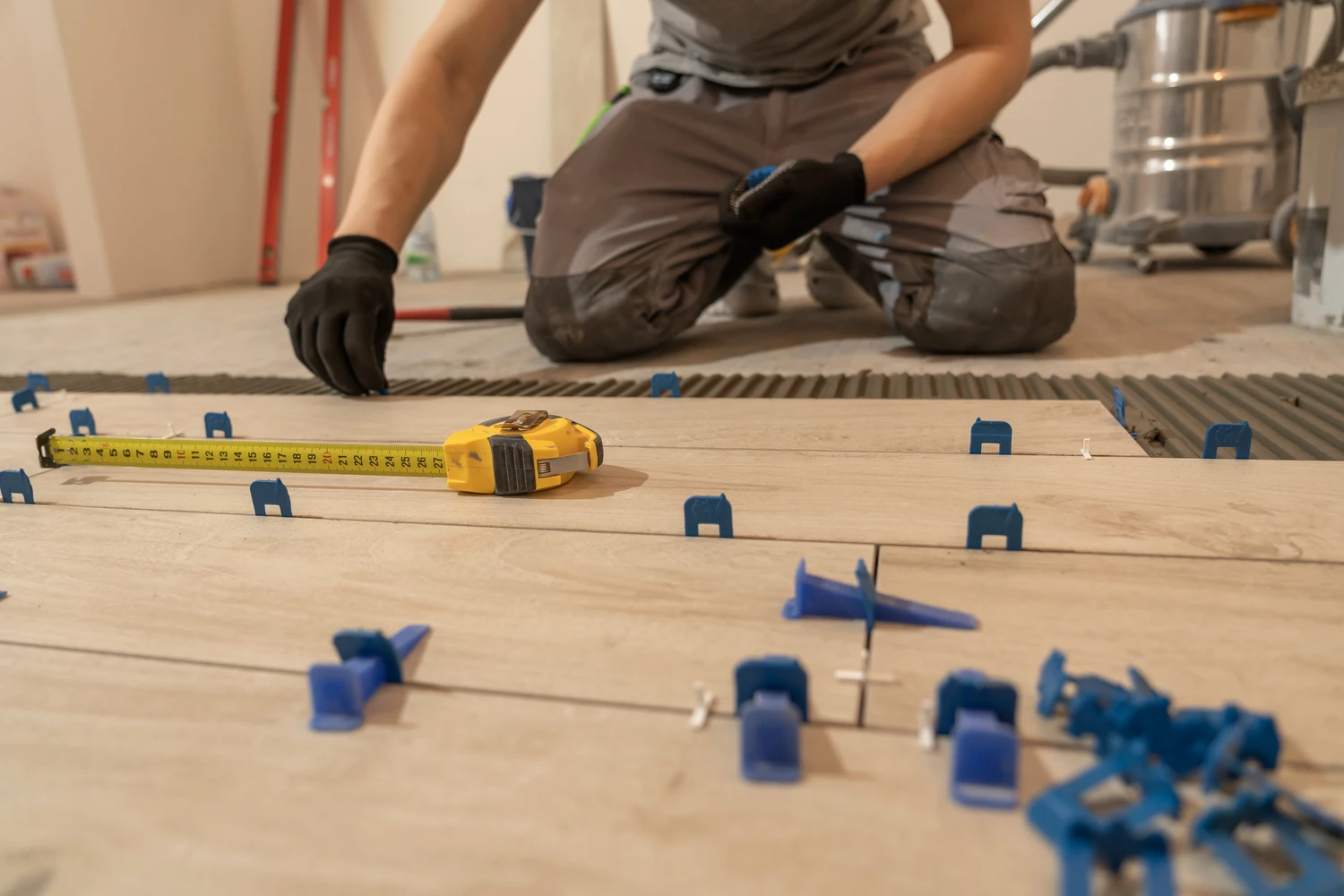 Repair and construction. Laying ceramic tiles using cement on the floor close-up. A man lays slabs on the floor and walls.<br />