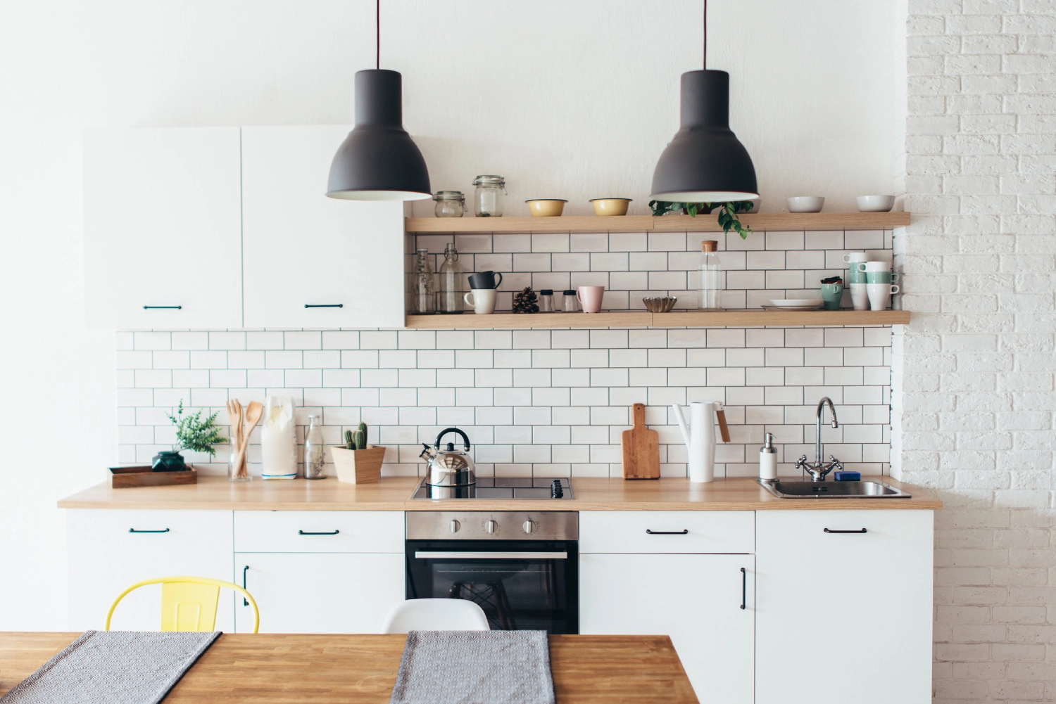 Modern new light interior of kitchen with white furniture and dining table.<br />
